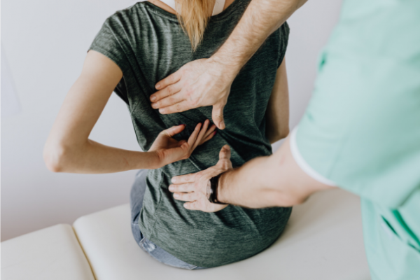 Woman having back examined 