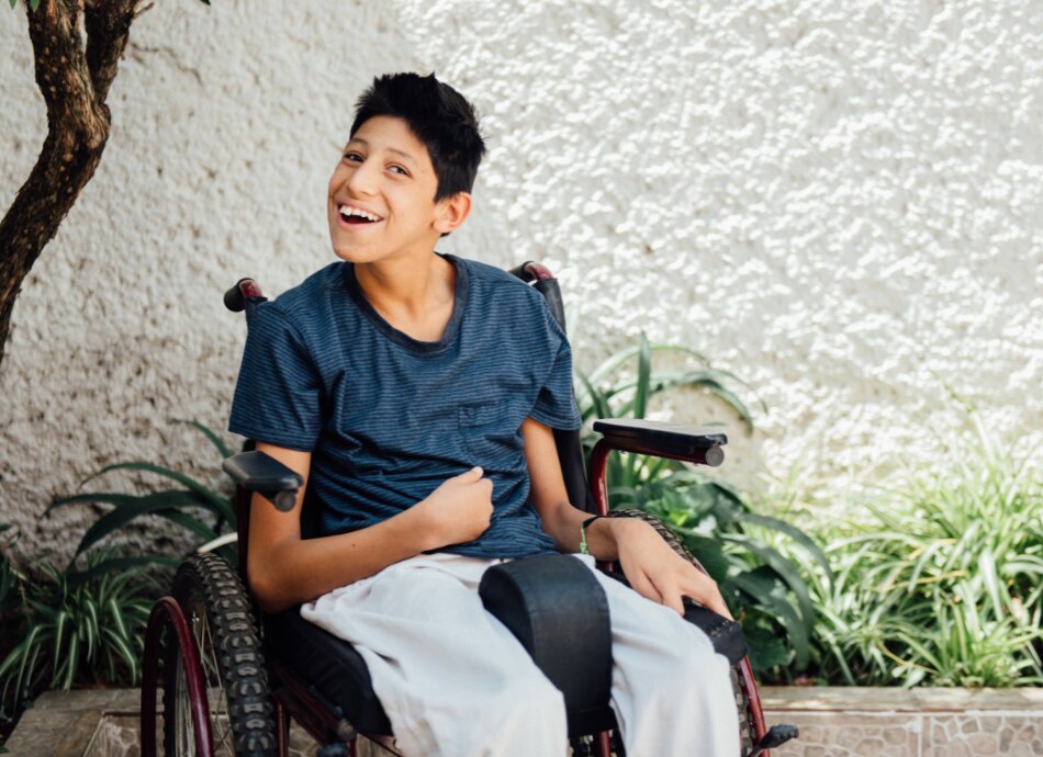 Young man with cerebral palsy smiling in his wheelchair