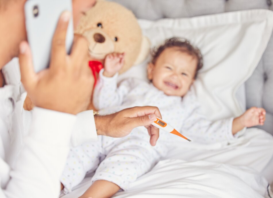 Parent holding thermometer calls for help while baby cries