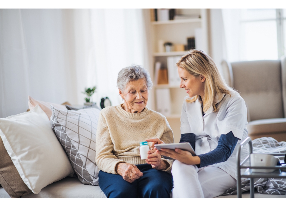 Healthcare worker advising older woman at home on taking medicine