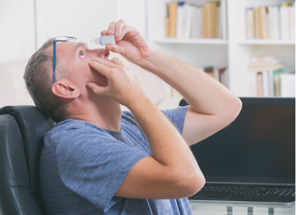 Man leans head back to put in eye drops