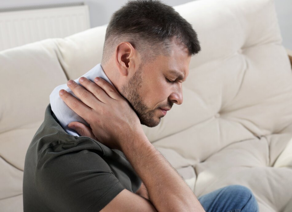 Man applying heat to neck 