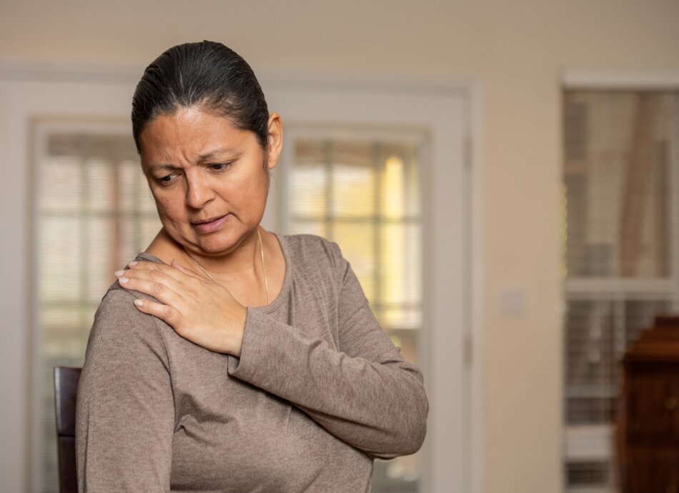 Woman touches painful right shoulder 