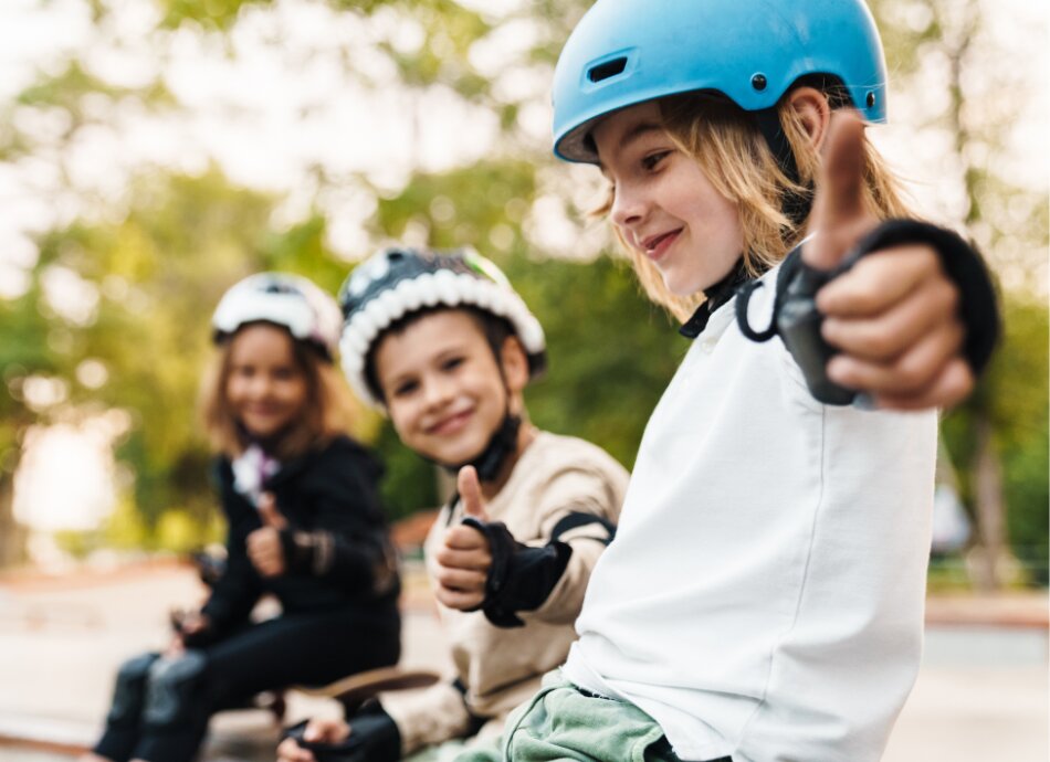 3 happy kids give thumbs-up at the skatepark