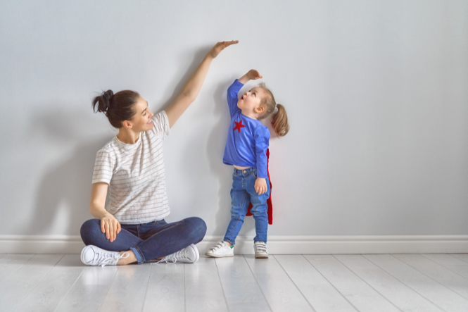 Mother holding hand up to measure daughter's height