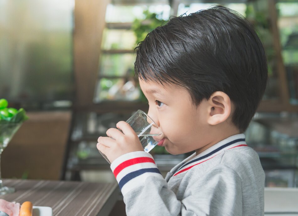 Young boy drinking glass of water