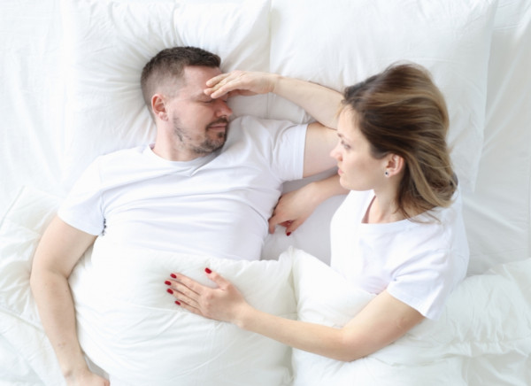 Woman waking her partner after he's been concussed