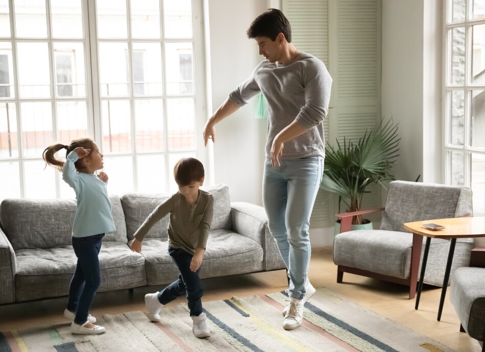 Father dancing with kids at home 