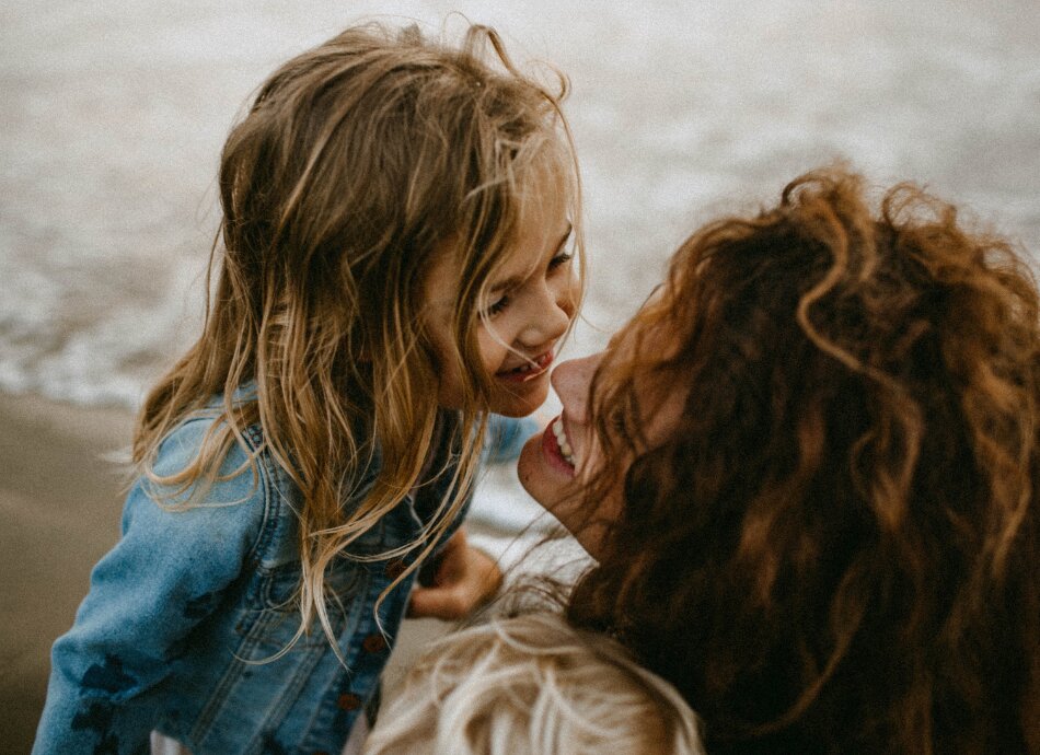 Mother and young daughter by the sea canva 950x690