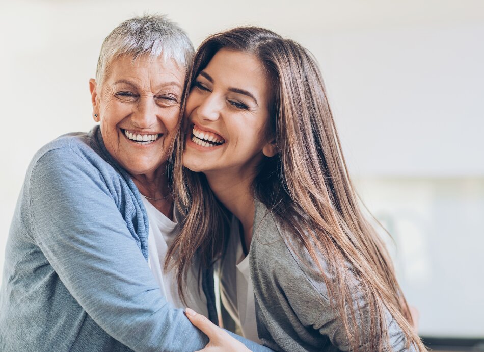 Older mother and daughter laughing canva 950x690