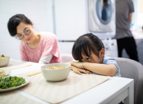 Young girl covering her face and not wanting to eat