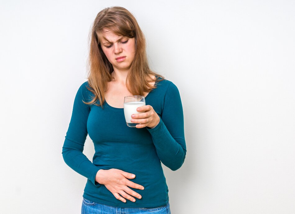 Frowning woman holding glass of milk is lactose intolerant