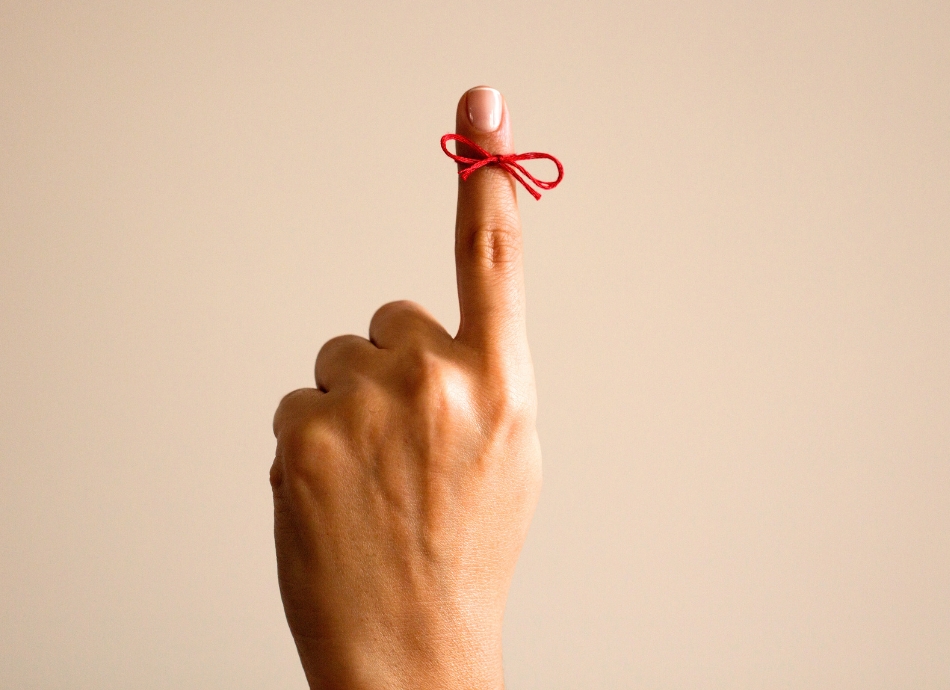 Finger with string knotted as reminder 