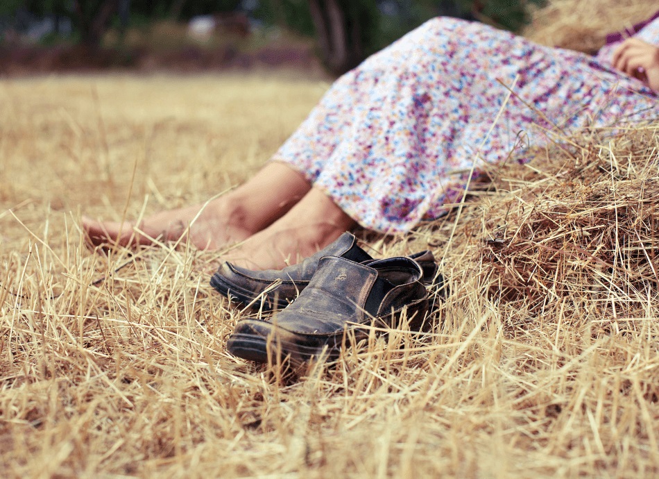 Old shoes taken off in hayfield canva 950x690