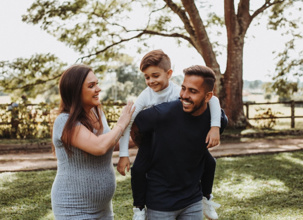 Pregnant woman with partner and child walking outside