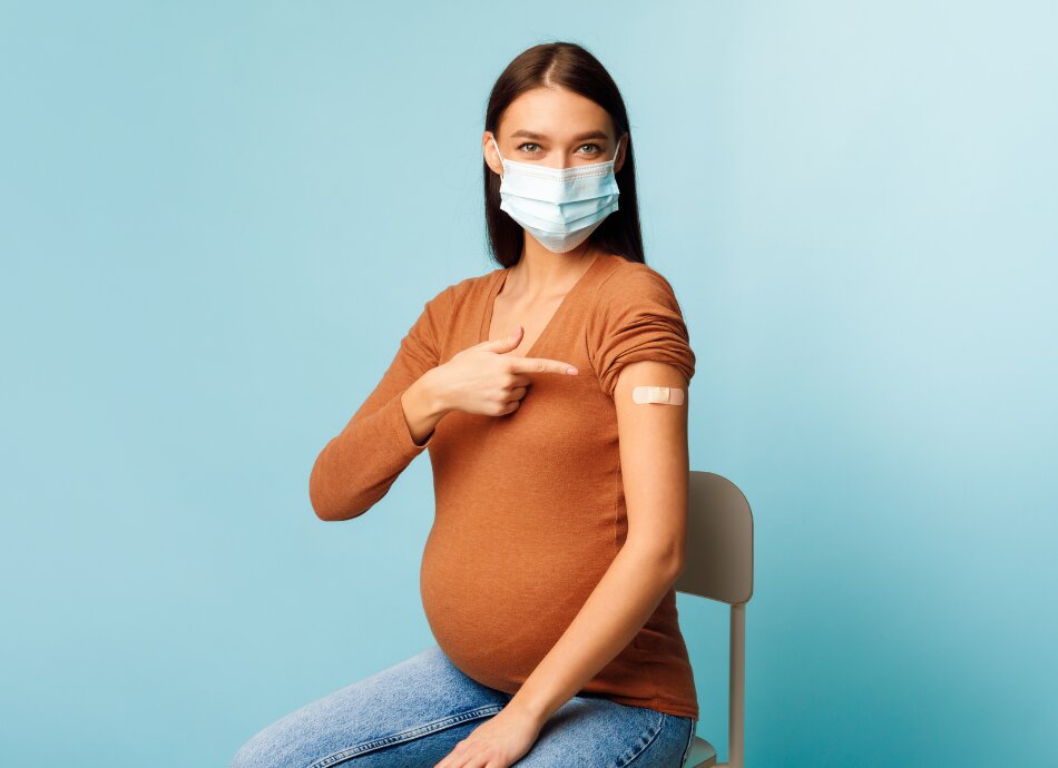 Vaccinated pregnant woman with bandaid on arm