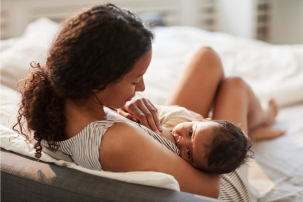 Mother breastfeeding with baby looking up