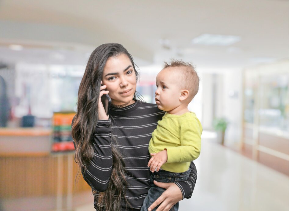 Young mum on phone while holding baby