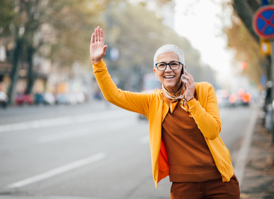 Older woman on cell-phone calling taxi 