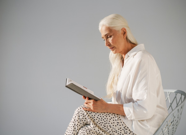 Woman sitting reading with legs crossed