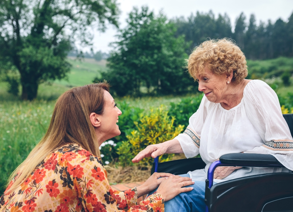 Woman in a wheelchair communicating with younger woman