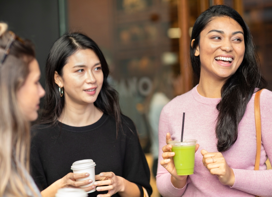 3 female friends smiling with takeaway juices