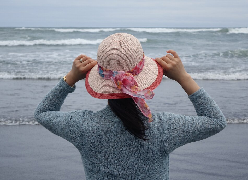 Woman looking out to sea with waves 