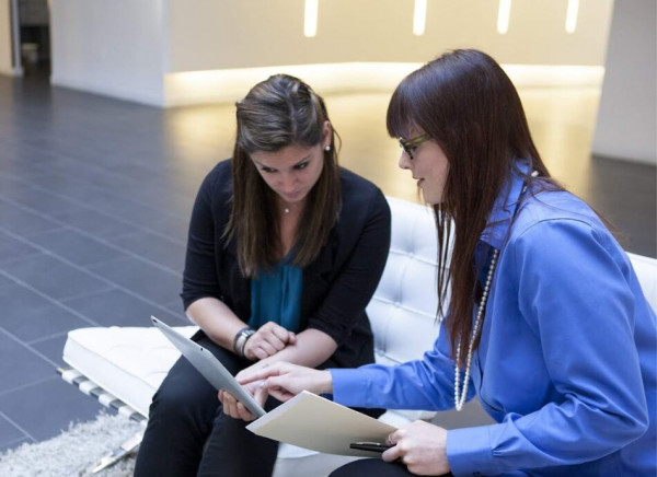 Young women looking at papers and chatting