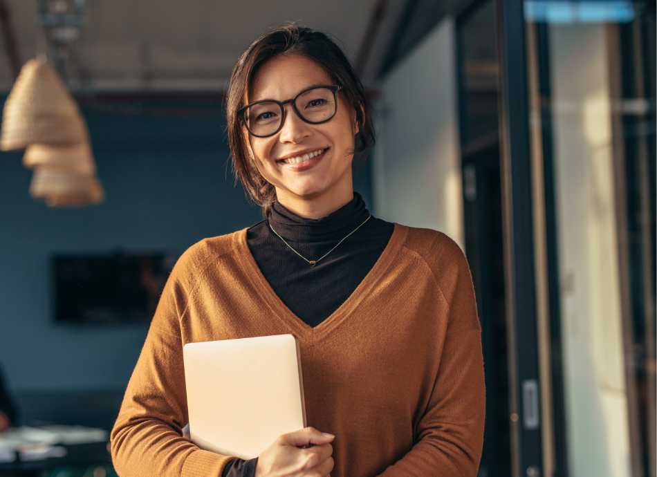 Smiling woman holding her laptop