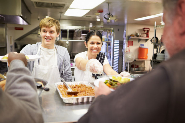 2 volunteers helping in soup kitchen