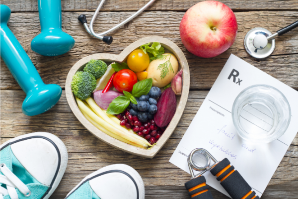 Handweights, health food and prescription pad on tabletop