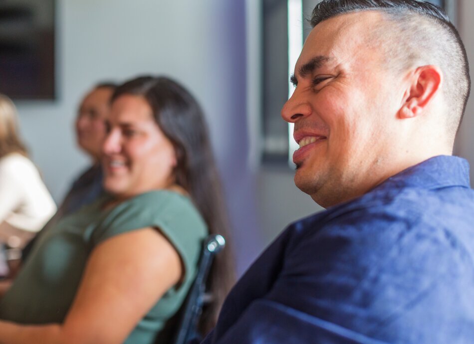 Businessman smiling in meeting with colleagues