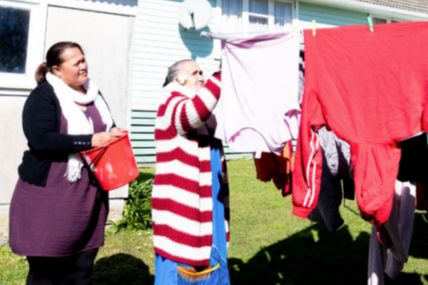 Daughter helps mother with hanging out clothes