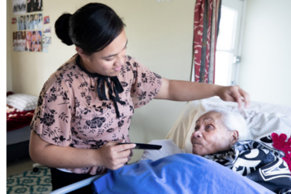 Granddaughter helps grandmother by combing hair